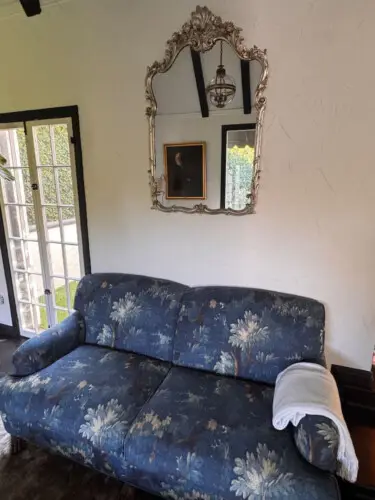 Blue floral sofa with mirror and framed artwork at Beverly Grove Tudor Family Home - by Open Air Homes.