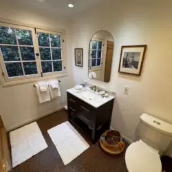 Bathroom with vanity and natural light at Beverly Grove Tudor Family Home - by Open Air Homes.