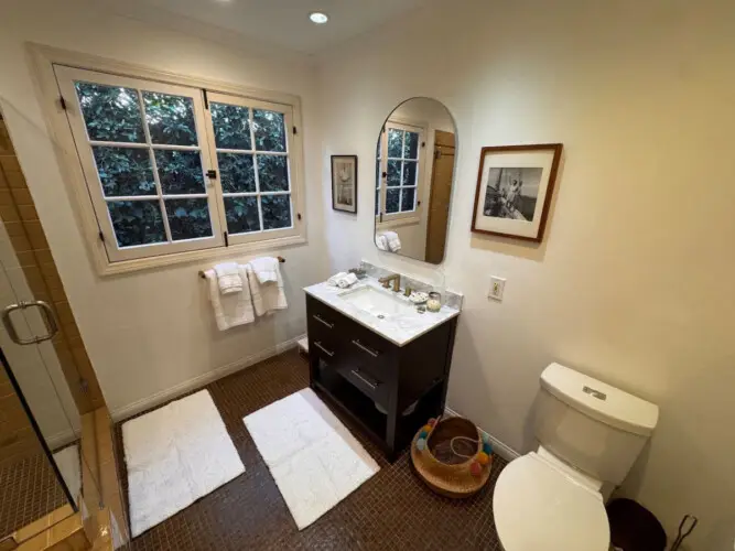 Bathroom with vanity and natural light at Beverly Grove Tudor Family Home - by Open Air Homes.