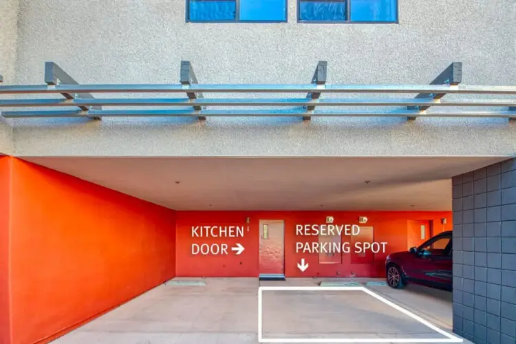 Parking area with reserved parking spot and kitchen door at La Mirage by Open Air Homes: Contemporary + Pool – by Open Air Homes.