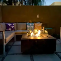 Outdoor seating area with fire pit and cushioned seating at La Mirage - by Open Air Homes