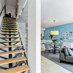 Modern staircase leading to upper level with view of living area at La Mirage gated community in Palm Springs, showcasing contemporary design – by Open Air Homes.