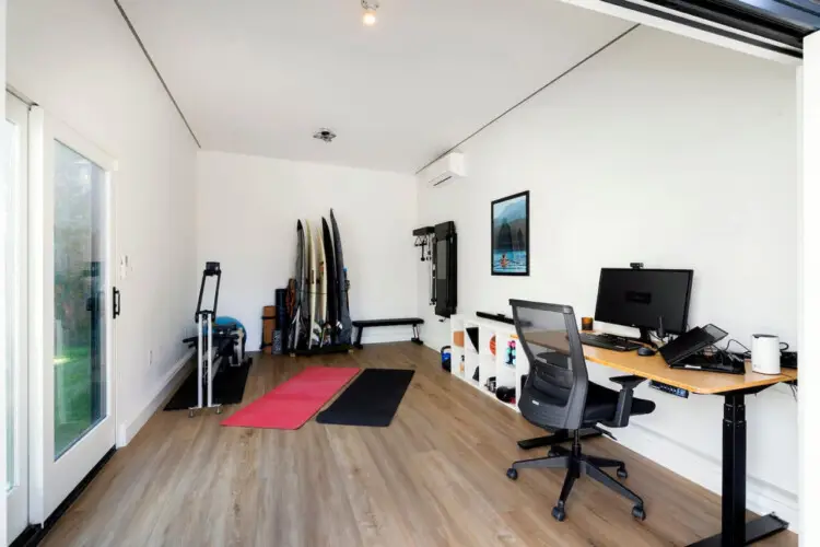 Multipurpose room with a desk, chairs, and surfboards at Sun-Drenched Spanish Manor in Mar Vista - by Open Air Homes.