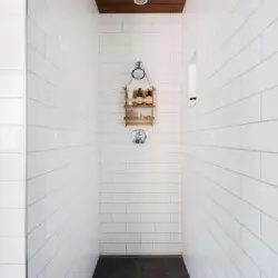 Shower area with white tiles and wooden ceiling at Sun-Drenched Spanish Manor in Mar Vista - by Open Air Homes.