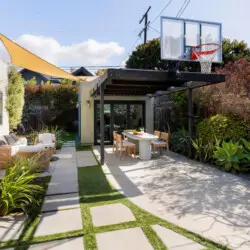 Outdoor dining area with table and chairs under a pergola at Sun-Drenched Spanish Manor in Mar Vista - by Open Air Homes.