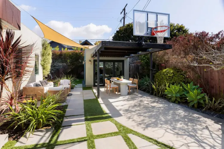 Outdoor dining area with table and chairs under a pergola at Sun-Drenched Spanish Manor in Mar Vista - by Open Air Homes.