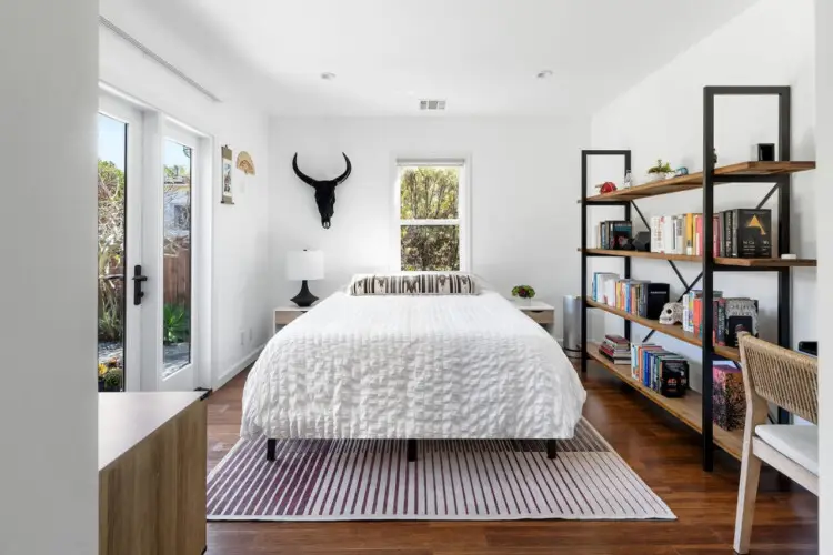 Bright bedroom with bed, bedside table, large windows, and stylish decor at Sun-Drenched Spanish Manor in Mar Vista - by Open Air Homes.