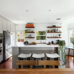 Bright kitchen with white cabinets, wooden countertops, and open shelving at Sun-Drenched Spanish Manor in Mar Vista - by Open Air Homes.