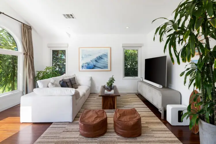 Living room with white sofa, rectangular coffee table, and large window at Sun-Drenched Spanish Manor in Mar Vista - by Open Air Homes.