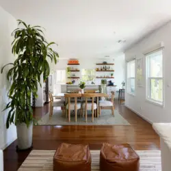 Dining area with wooden table and chairs, view of living room at Sun-Drenched Spanish Manor in Mar Vista - by Open Air Homes.