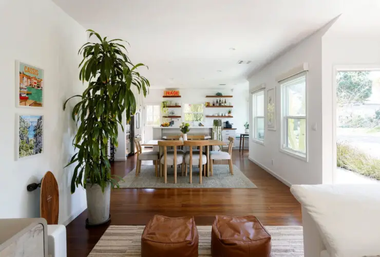 Dining area with wooden table and chairs, view of living room at Sun-Drenched Spanish Manor in Mar Vista - by Open Air Homes.