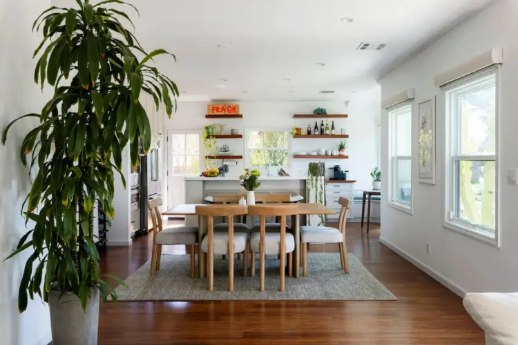 Dining area with wooden table and chairs, view of kitchen at Sun-Drenched Spanish Manor in Mar Vista - by Open Air Homes.