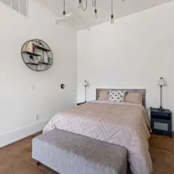 Bedroom with bed, pillows, and bench at Skyline View Loft with Chef's Kitchen: DTLA - by Open Air Homes.