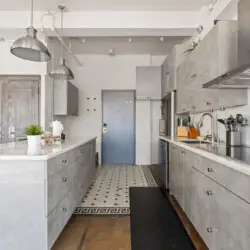 Modern kitchen with central island, pendant lighting, and wine cooler at Skyline View Loft with Chef's Kitchen: DTLA - by Open Air Homes.