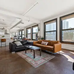 Spacious loft interior with modern design, large windows, and comfortable seating at Skyline View Loft with Chef's Kitchen: DTLA - by Open Air Homes.