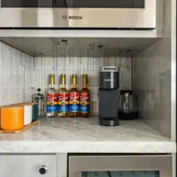 Kitchen counter with coffee machine and bottles at Skyline View Loft with Chef's Kitchen: DTLA - by Open Air Homes.