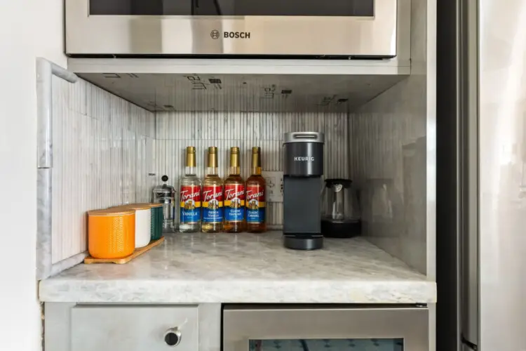 Kitchen counter with coffee machine and bottles at Skyline View Loft with Chef's Kitchen: DTLA - by Open Air Homes.