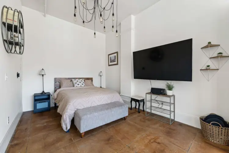 Comfortable bedroom with a bed, side tables, TV, and decorative elements at Skyline View Loft with Chef's Kitchen: DTLA - by Open Air Homes.