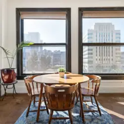 Dining area with round table and city views at Skyline View Loft with Chef's Kitchen: DTLA - by Open Air Homes.