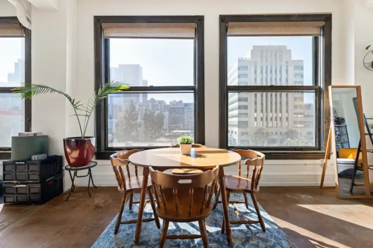 Dining area with round table and city views at Skyline View Loft with Chef's Kitchen: DTLA - by Open Air Homes.