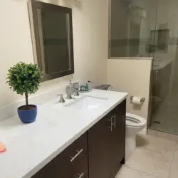 Bathroom with vanity, mirror, and glass shower at Sunrise Serenity: Panoramic Views & Resort Living - by Open Air Homes