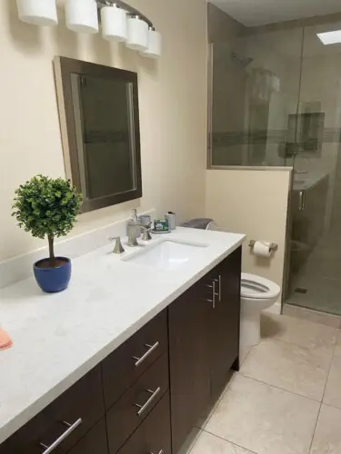 Bathroom with vanity, mirror, and glass shower at Sunrise Serenity: Panoramic Views & Resort Living - by Open Air Homes