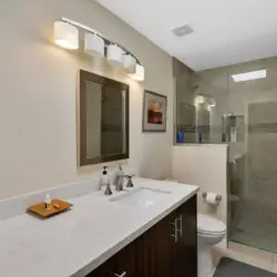 Bathroom with sink, mirror, and shower at Sunrise Serenity: Panoramic Views & Resort Living - by Open Air Homes