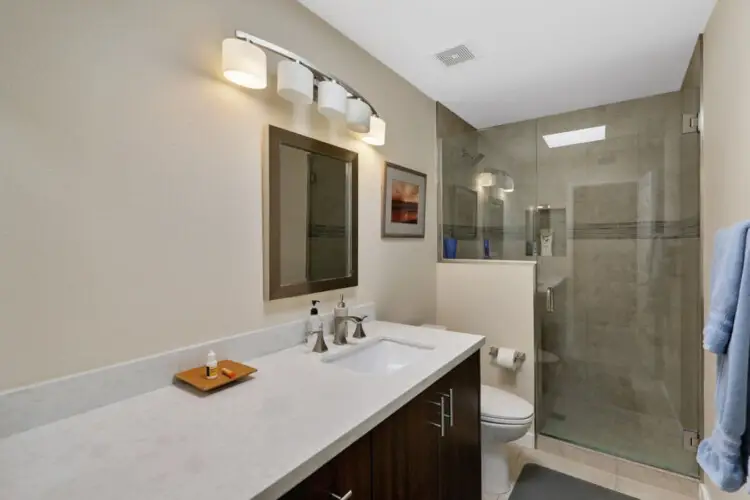 Bathroom with sink, mirror, and shower at Sunrise Serenity: Panoramic Views & Resort Living - by Open Air Homes