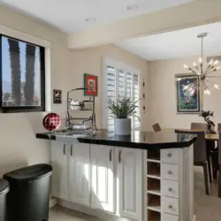 Dining room with table and chairs, and kitchen counter with cabinets at Sunrise Serenity: Panoramic Views & Resort Living - by Open Air Homes