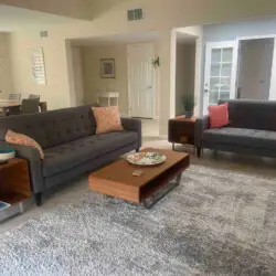 Living room with two sofas, coffee table, and dining area at Sunrise Serenity: Panoramic Views & Resort Living - by Open Air Homes