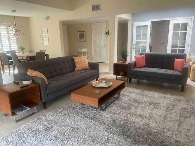 Living room with two sofas, coffee table, and dining area at Sunrise Serenity: Panoramic Views & Resort Living - by Open Air Homes