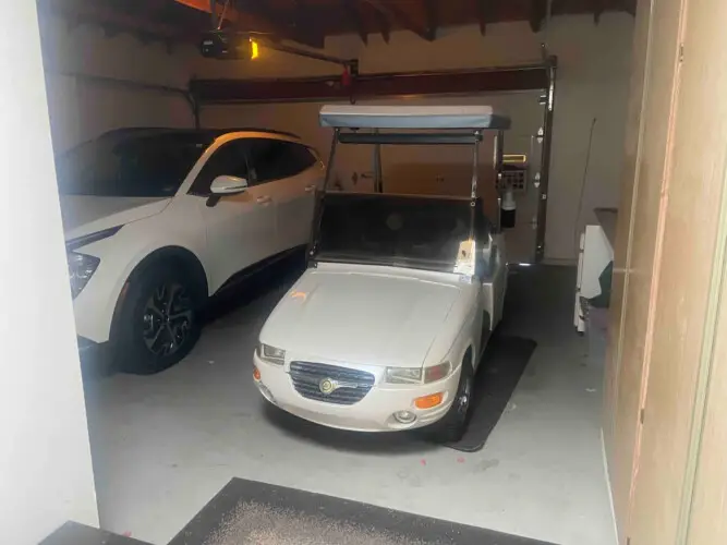 Garage with car and golf cart at Sunrise Serenity: Panoramic Views & Resort Living - by Open Air Homes