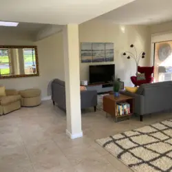 Living room with sofa, armchair, coffee table, and TV at Sunrise Serenity: Panoramic Views & Resort Living - by Open Air Homes