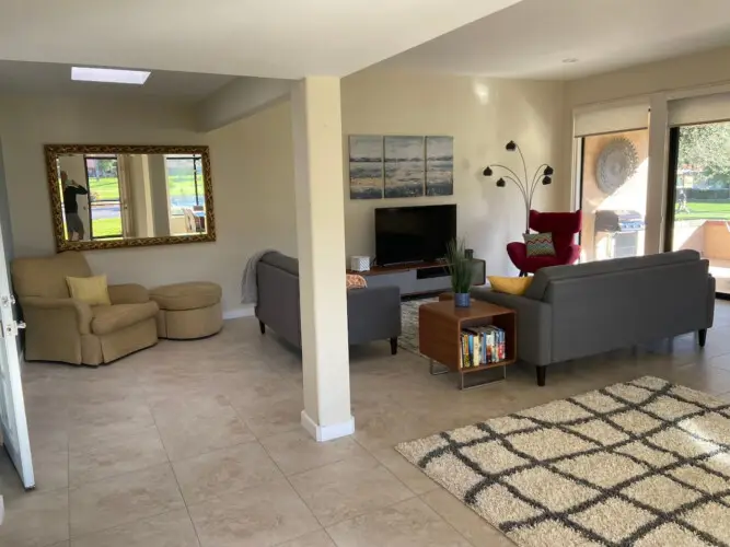 Living room with sofa, armchair, coffee table, and TV at Sunrise Serenity: Panoramic Views & Resort Living - by Open Air Homes