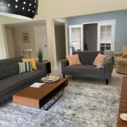 Living room with gray sofas, wooden coffee table, and rug at Sunrise Serenity: Panoramic Views & Resort Living - by Open Air Homes