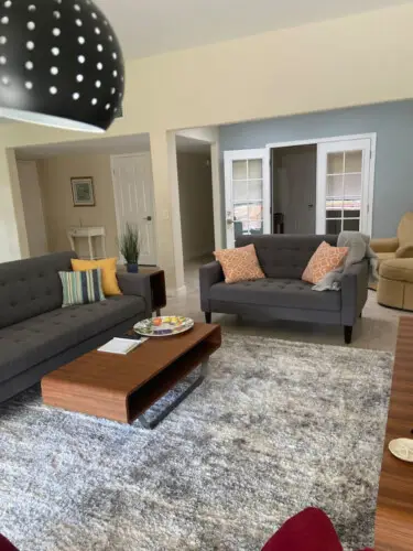 Living room with gray sofas, wooden coffee table, and rug at Sunrise Serenity: Panoramic Views & Resort Living - by Open Air Homes