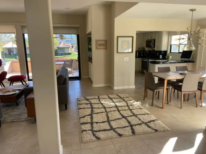 Dining area with table and chairs, and living area in the background at Sunrise Serenity: Panoramic Views & Resort Living - by Open Air Homes