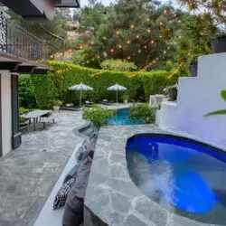 Pool and spa area with stone deck and outdoor seating at Laurel Canyon Classic Hollywood Residence W/ Pool by Open Air Homes.