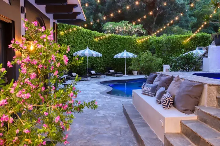 Outdoor pool area with seating and greenery at Laurel Canyon Classic Hollywood Residence by Open Air Homes.