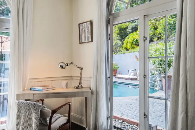 Cozy reading nook with a view of the pool at Laurel Canyon Classic Hollywood Residence W/ Pool by Open Air Homes.