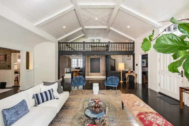 Spacious living room in Laurel Canyon Classic Hollywood Residence W/ Pool featuring a vaulted ceiling, large sofa, armchairs, coffee table, and decorative elements by Open Air Homes.