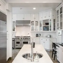 Kitchen with island and stainless steel appliances at Laurel Canyon Classic Hollywood Residence W/ Pool by Open Air Homes.