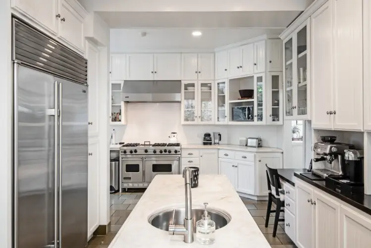 Kitchen with island and stainless steel appliances at Laurel Canyon Classic Hollywood Residence W/ Pool by Open Air Homes.