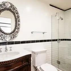 Bathroom interior of Laurel Canyon Classic Hollywood Residence W/ Pool featuring a vanity with a decorative mirror, toilet, and glass-enclosed shower by Open Air Homes.