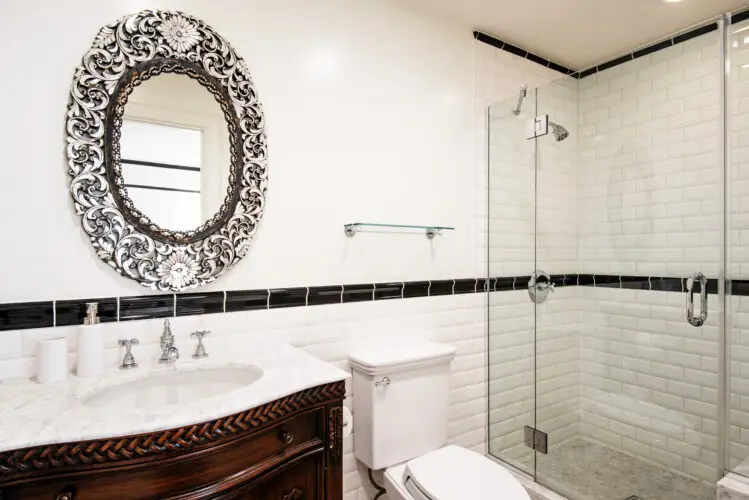 Bathroom interior of Laurel Canyon Classic Hollywood Residence W/ Pool featuring a vanity with a decorative mirror, toilet, and glass-enclosed shower by Open Air Homes.