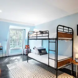 Bedroom interior of Laurel Canyon Classic Hollywood Residence W/ Pool featuring a bunk bed, desk, and window with natural light by Open Air Homes.