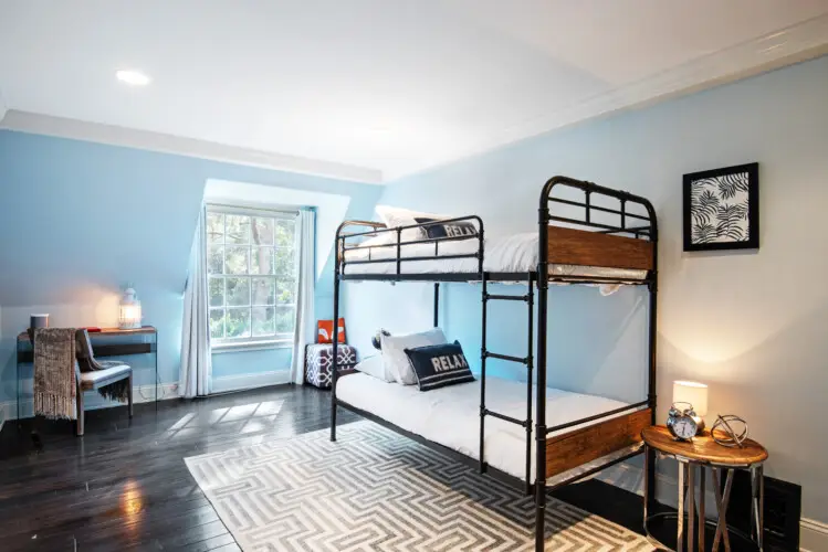 Bedroom interior of Laurel Canyon Classic Hollywood Residence W/ Pool featuring a bunk bed, desk, and window with natural light by Open Air Homes.