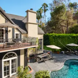 Exterior view of Laurel Canyon Classic Hollywood Residence W/ Pool with balcony, outdoor seating, and swimming pool surrounded by greenery by Open Air Homes.