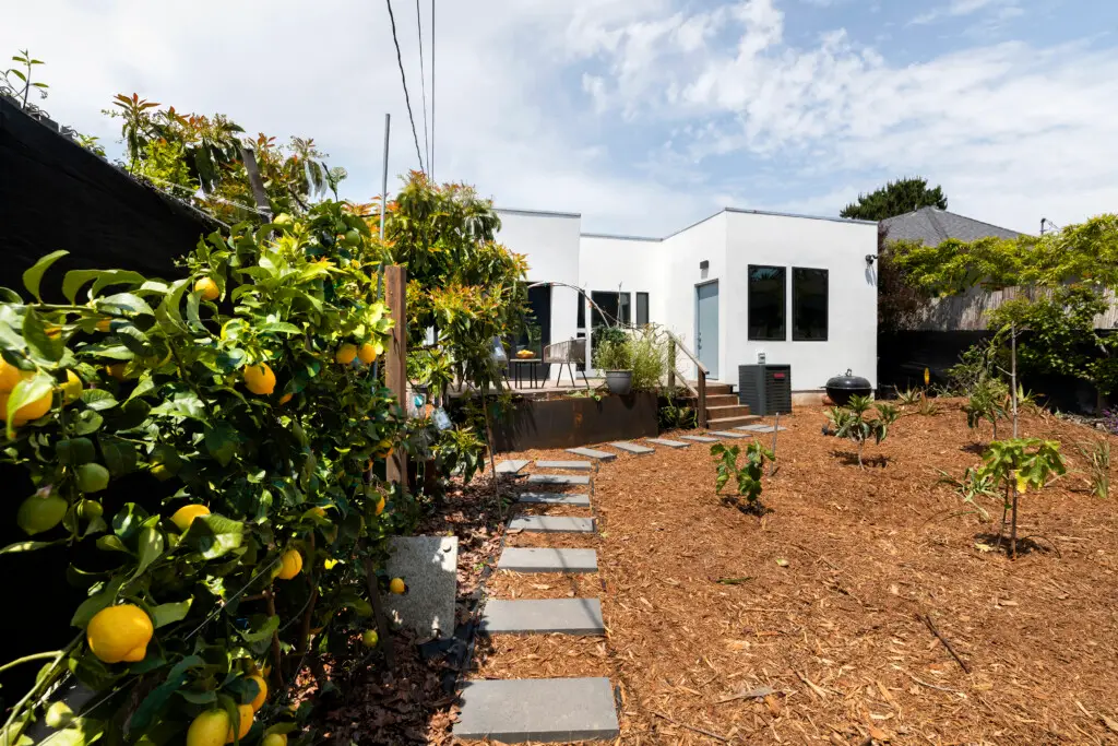 Mount Washington Airbnb Management - Outdoor area with white house, patio, and garden in Venice Beach rental