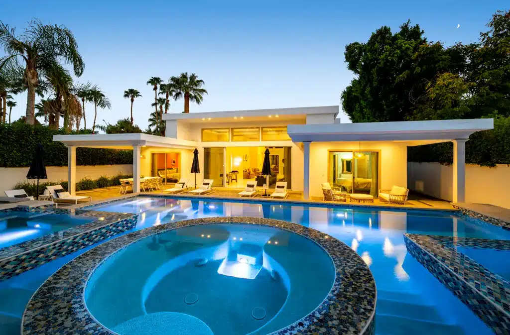 Palm Springs Airbnb Occupancy Rate: Our Homes Hold 41% of Nights 9 Palm Springs Airbnb Occupancy Rate - Luxurious outdoor pool area with hot tub and modern house at Open Air Homes' luxury vacation rental.